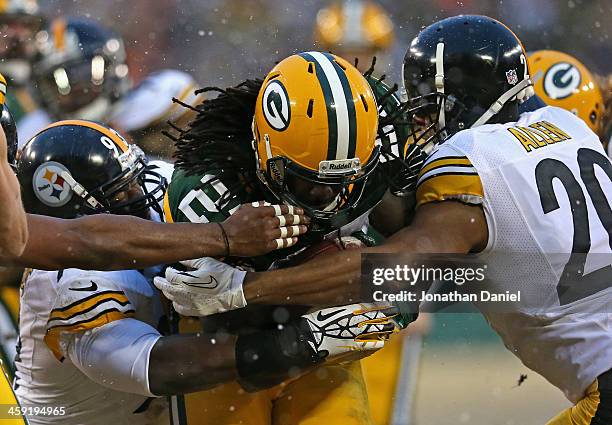 Eddie Lacy of the Green Bay Packers is hit by Jason Worilds and Cortez Alen of the Pittsburgh Steelers at Lambeau Field on December 22, 2013 in Green...
