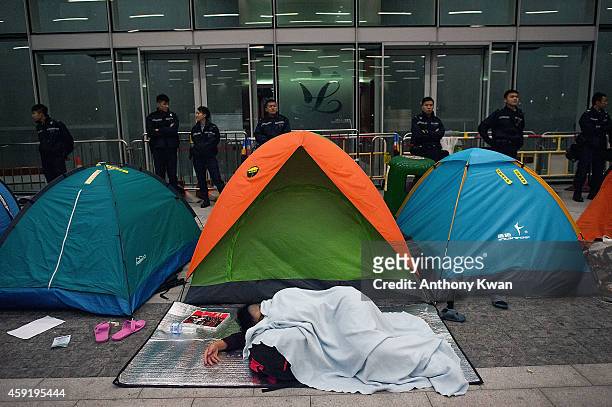 Pro-democracy protester sleeps on the floor outside the Legislative Council building entrance after clashes with police on November 19, 2014 in Hong...