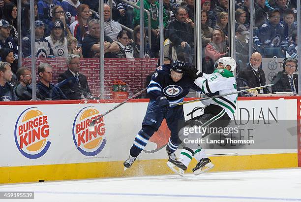Grant Clitsome of the Winnipeg Jets collides with Erik Cole of the Dallas Stars during third period action at the MTS Centre on December 14, 2013 in...