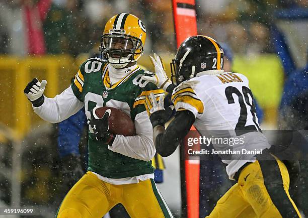 James Jones of the Green Bay Packers runs after a first down catch chased by Cortez Allen of the Pittsburgh Steelers at Lambeau Field on December 22,...