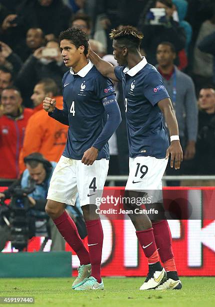 Raphael Varane of France celebrates scoring a goal for his team with teammate Paul Pogba during the international friendly match between France and...