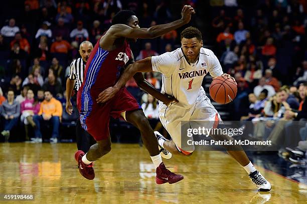 Justin Anderson of the Virginia Cavaliers drives against against Greg Mortimer of the South Carolina State Bulldogs during the first half of a game...