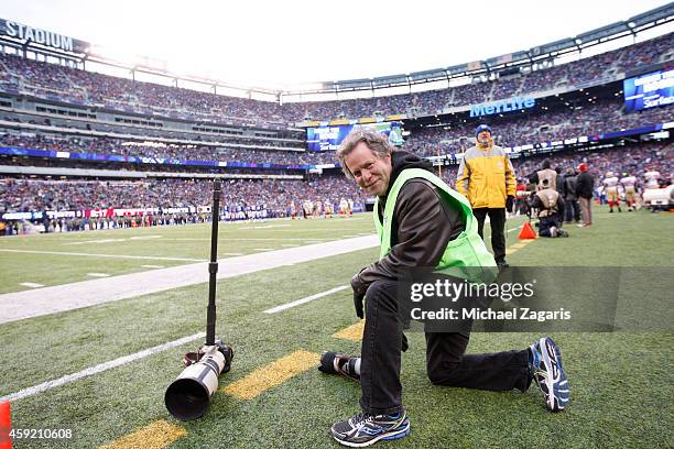 Fipboard photo editor Steve Fine kneels on the sideline during the game between the San Francisco 49ers and the New York Giants at Metlife Stadium on...
