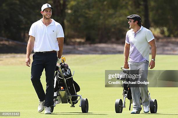 Geelong Cats AFL footballer Tom Hawkins and former AFL footballer Campbell Brown walk down a fairway during the Pro-Am ahead of the 2014 Australian...