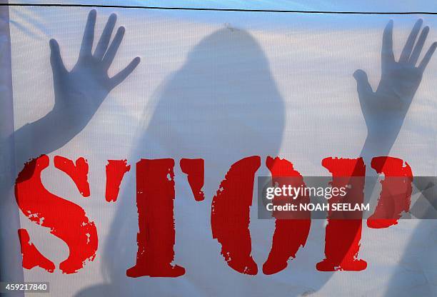 An Indian school student's shadow falls on a banner during an awareness Campaign against Child Sex Abuse in Hyderabad on November 19 the World Day...