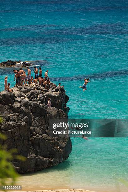 jumping off rock on oahu, hawaii - haleiwa 個照片及圖片檔