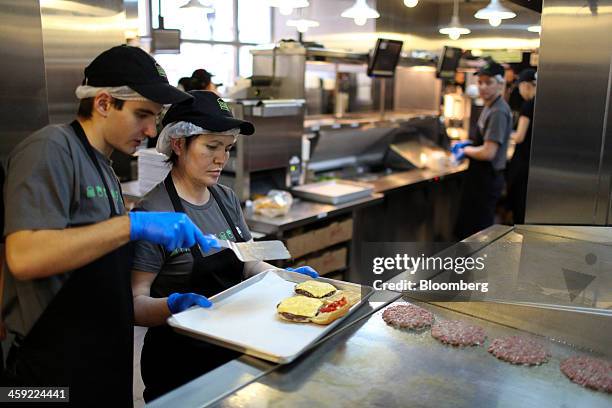 Workers prepare hamburgers in the kitchen of the first Shake Shack burger restaurant to open in Moscow, Russia, on Tuesday, Dec. 24, 2013. The New...