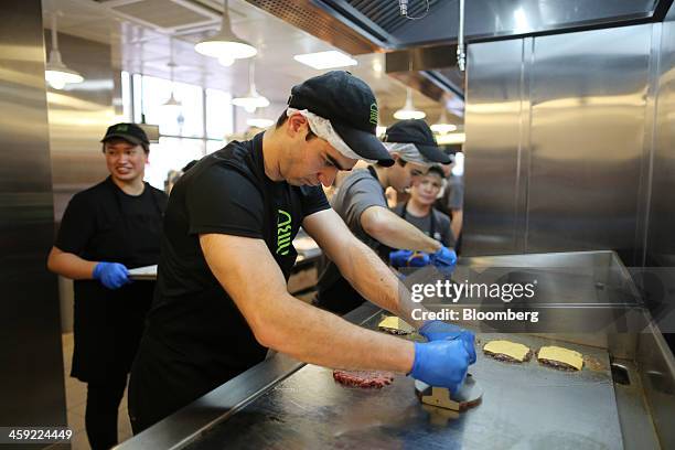 Worker grills hamburger patties at a fryer in the kitchen of the first Shake Shack burger restaurant to open in Moscow, Russia, on Tuesday, Dec. 24,...