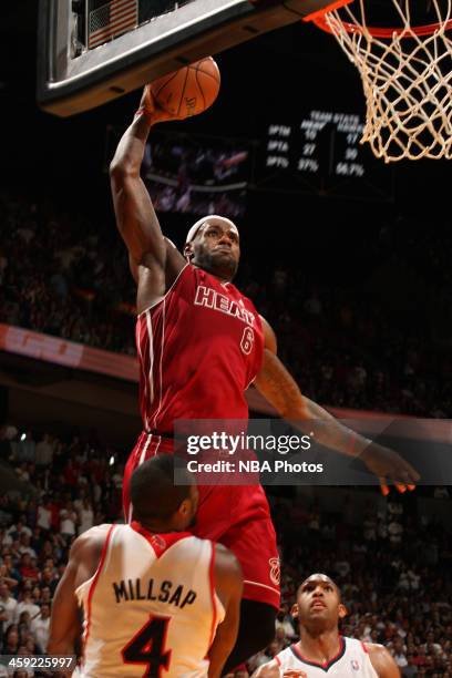 LeBron James of the Miami Heat dunks the ball against Paul Millsap of the Atlanta Hawks on December 23, 2013 at American Airlines Arena in Miami,...