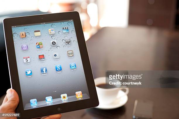 person holding an ipad showing the home screen - homescreen stock pictures, royalty-free photos & images