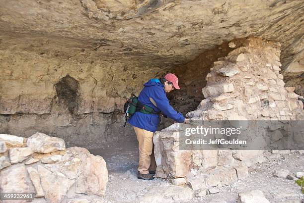 woman hiker viewing an ancient cliff dwelling - sinagua stock pictures, royalty-free photos & images