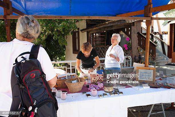 merchant talks with customer at rougemont brocante stand - grasse 個照片及圖片檔