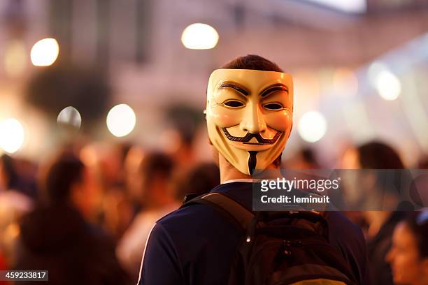 protester wearing a guy fawkes mask. - guy fawkes stock pictures, royalty-free photos & images