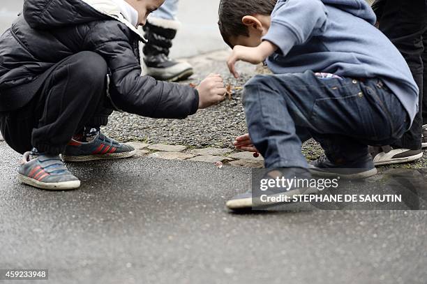 Pupils play marbles on November 19, 2014 at the Jean-Rostand school in the northern Paris suburb city of Bondy. AFP PHOTO / STEPHANE DE SAKUTIN