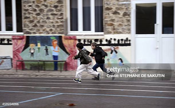Two pupils play in the schoolyard of the Jean-Rostand school in the northern Paris suburb city of Bondy on November 19, 2014. AFP PHOTO / STEPHANE DE...