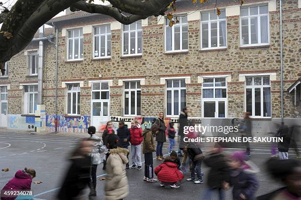 Pupils play in the schoolyard of the Jean-Rostand school in the northern Paris suburb city of Bondy, on November 19, 2014. AFP PHOTO / STEPHANE DE...