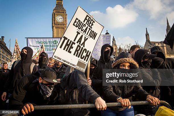 Protestors try to remove barriers surrounding Parliament Square during a march against student university fees on November 19, 2014 in London,...
