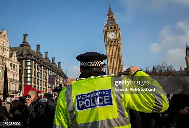 Policeman raises his baton as a march against student university fees passes the Houses of Parliament on November 19, 2014 in London, England. A...