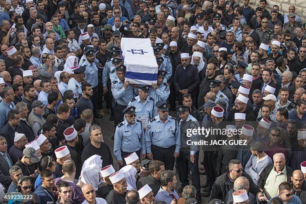 Israeli police officers carry the coffin of their comrade Zidan Saief a member of Israel's Druze minority, during his funeral in his northern home...