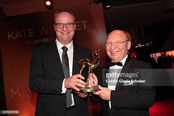 Cast members of the tv show 'heute show', Oliver Welke and Hans-Joachim Heist, pose with their award during Kryolan at the Bambi Awards 2014 on...