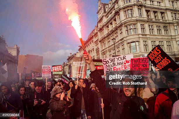 Protester holds up a flare during a march against student university fees near the Houses of Parliament on November 19, 2014 in London, England. A...