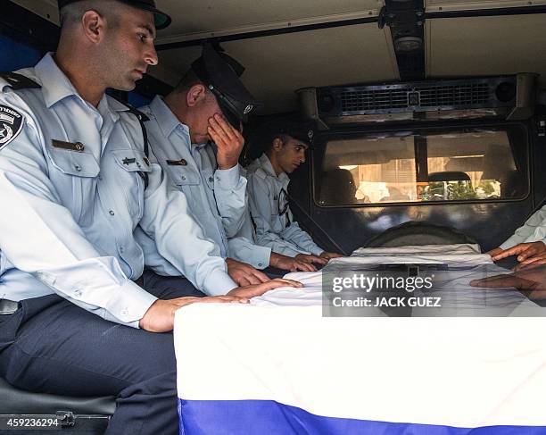 Police officers mourn next to the coffin of Israeli police officer Zidan Saief a member of Israel's Druze minority, during his funeral in his...