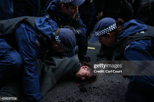 Police detain a protester after scuffles during a demonstration against fees and cuts in the education system on November 19, 2014 in London,...