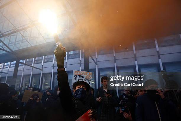 Protester holds a flare during a demonstration against fees and cuts in the education system on November 19, 2014 in London, England. A coalition of...