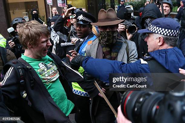 Protester scuffles with a police officer during a protest against fees and cuts in the education system on November 19, 2014 in London, England. A...