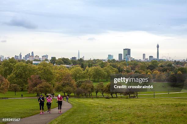 early morning joggers at primrose hill before london skyline - lambeth stock pictures, royalty-free photos & images