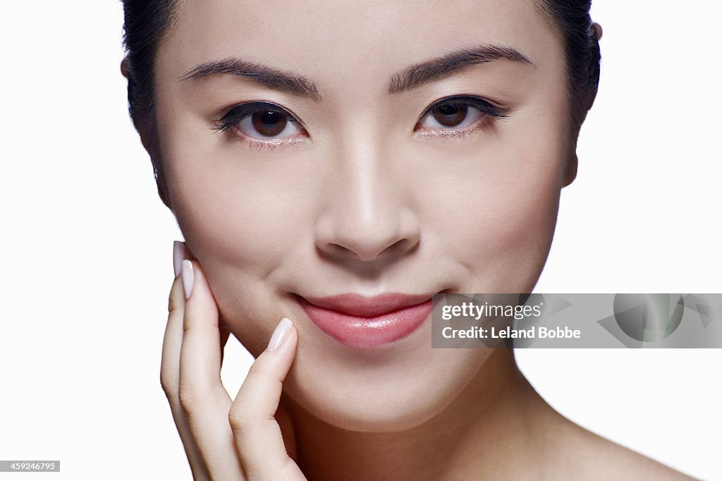 Beauty shot of Asian woman with hand to face