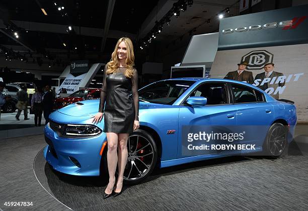 Model poses with a Dodge Charger at the Los Angeles Auto Show, November 19, 2014 in Los Angeles, California. AFP PHOTO / ROBYN BECK