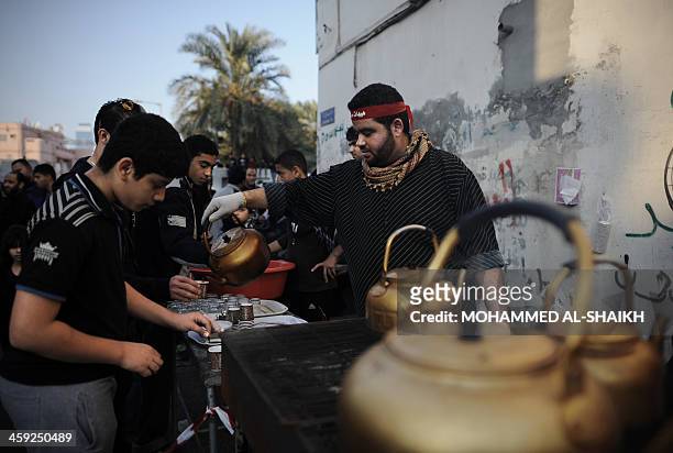 Bahraini Shiite Muslim man serves tea to shiite Muslims in the village of Sanabis, west of Manama, on December 24 during the Arbaeen religious...