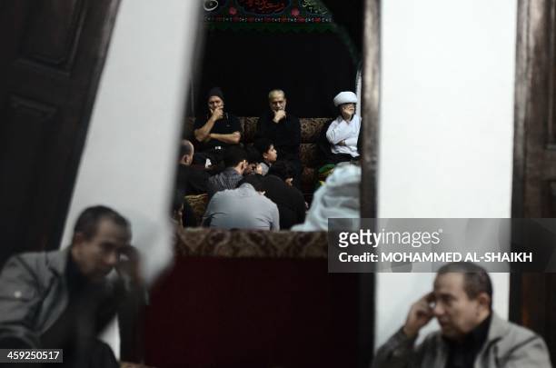 Bahraini Shiite Muslims sit contemplating the death of religious figure Imam Hussein in the village of Sanabis, west of Manama, on December 24 as...