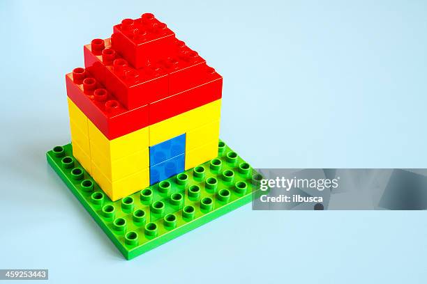 small lego house made with lego (duplo) on turquoise background. - building lego stock pictures, royalty-free photos & images