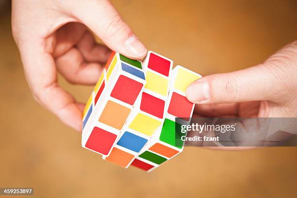 hands playing a cube game - rubik's cube stockfoto's en -beelden