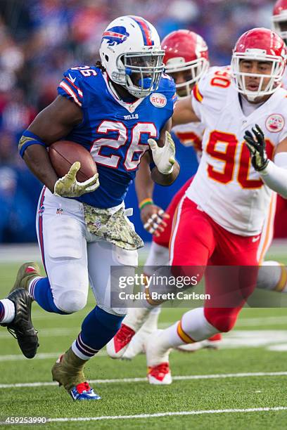 Anthony Dixon of the Buffalo Bills carries the ball as Josh Mauga of the Kansas City Chiefs pursues on November 9, 2014 at Ralph Wilson Stadium in...