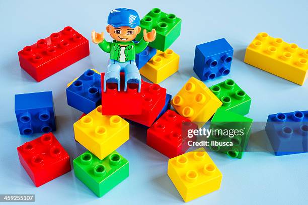 happy lego man sit on top of bricks - building lego stock pictures, royalty-free photos & images