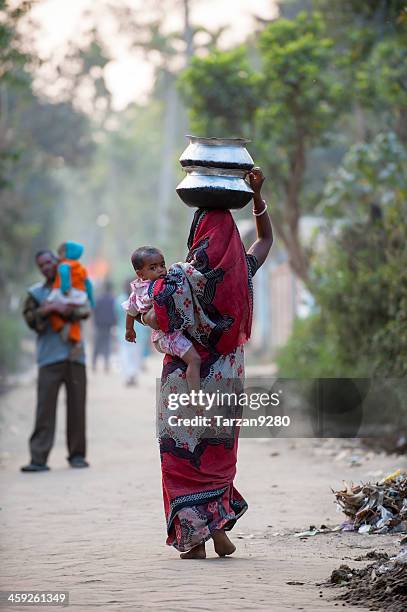 bengali woman carrying baby and water jar in village - bangladesh village stock pictures, royalty-free photos & images