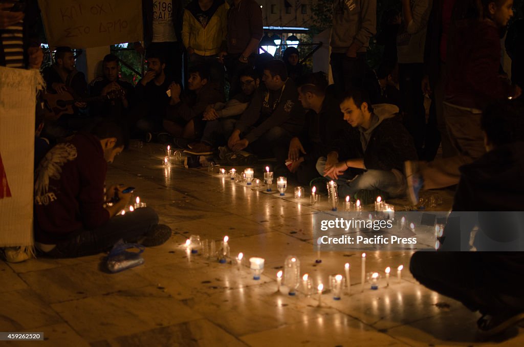 Syrians hold lighted candles sitting on Syntagma sqaure.