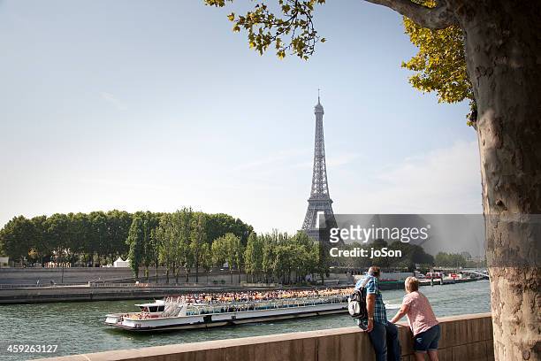 couple looking at eiffel tower and the sein river - river cruise stock pictures, royalty-free photos & images