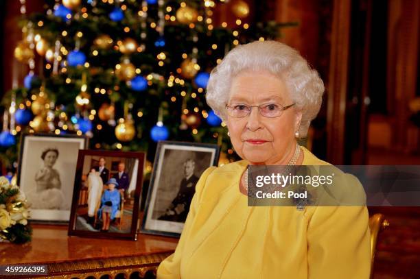 Queen Elizabeth II records her Christmas message to the Commonwealth, in the Blue Drawing Room at Buckingham Palace on December 12, 2013 in London...