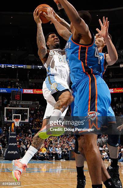 Wilson Chandler of the Denver Nuggets gets off a shot against Lance Thomas and Steven Adams of the Oklahoma City Thunder at Pepsi Center on November...