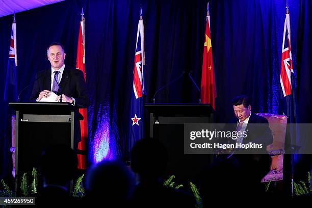 Prime Minister John Key of New Zealand speaks while President Xi Jinping of China looks on during a signing of NZ-China agreements at Premiere House...