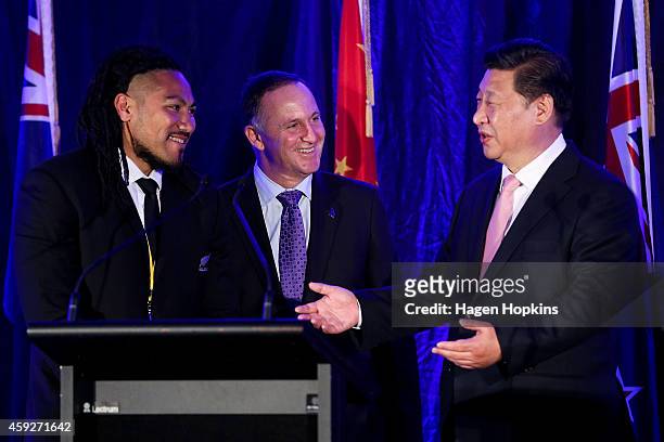 To R, All Black Ma'a Nonu and Prime Minister John Key of New Zealand look on while President Xi Jinping of China speaks during a signing of NZ-China...