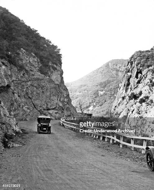 An car with a badge on the license plate coming up Topanga Canyon Road in the Santa Monica Mountains, Topanga, California, circa 1922.
