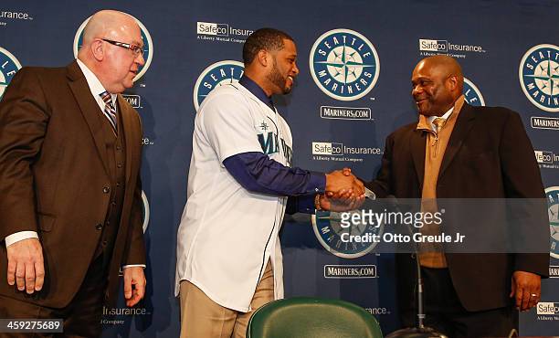 Manager Lloyd McClendon of the Seattle Mariners shakes hands with Robinson Cano as GM Jack Zduriencik looks on during Cano's introductory press...