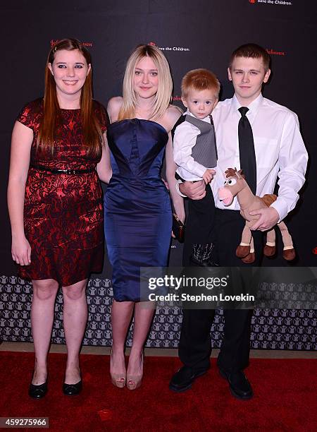 Dakota Fanning poses with LaShawna Long, Trenton and Cody Smallwood of Manchester, KY at Save the Childrens Illumination Gala in New York City on...