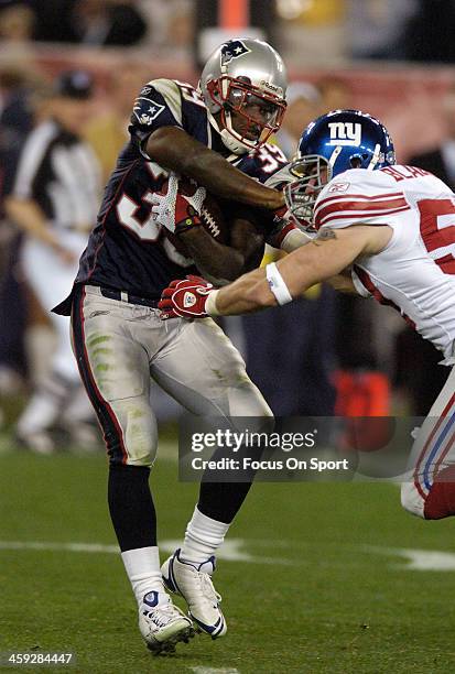 Laurence Maroney of the New England Patriots gets tackled by Chase Blackburn of the New York Giants during Super Bowl XLII on February 3, 2008 at...