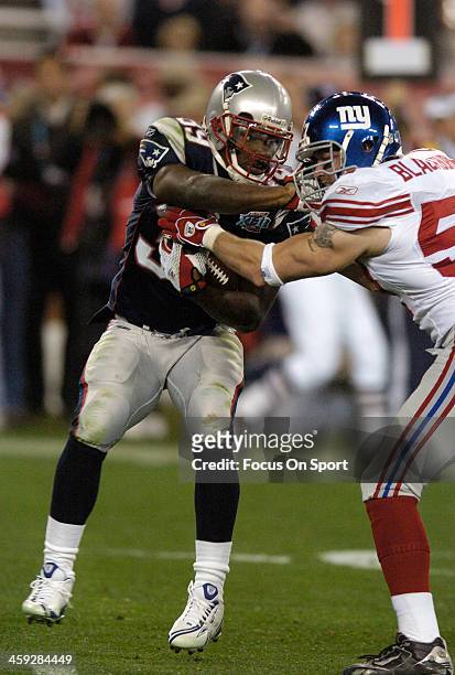 Laurence Maroney of the New England Patriots gets tackled by Chase Blackburn of the New York Giants during Super Bowl XLII on February 3, 2008 at...